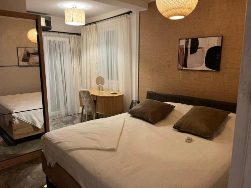 a bedroom with a bed and a table with a mirror at Apartmani Vukotić in Budva