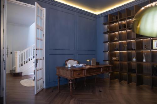 a room with a desk and a blue wall at Roma Nueve Dos Hotel Boutique in Mexico City