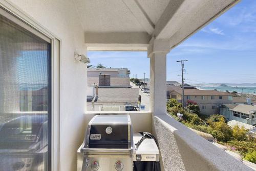 a balcony with a grill and a view of the ocean at Park Avenue Beach Life in Cayucos