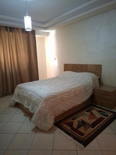 a bedroom with a bed and a rug on the floor at appartement 3 gare tgv in Kenitra