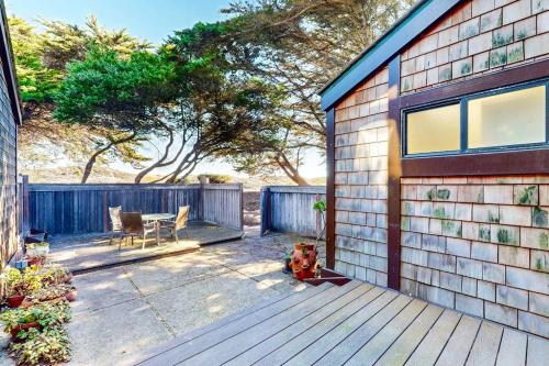 a dog sitting on a deck next to a house at Rita's-by-the-Sea in Moss Landing