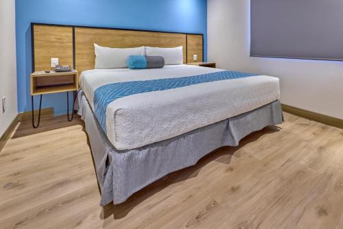 ein Schlafzimmer mit einem großen Bett und einem Tisch in der Unterkunft Continental Mexicano in Mexiko-Stadt