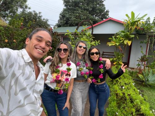 a group of people standing in front of a house with flowers at Cabañas Anariki in Hanga Roa
