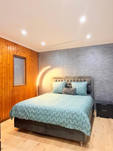 a bedroom with a bed with a blue comforter at Maison privative SPA Jacuzzi Sauna Salle de jeux in Weitbruch