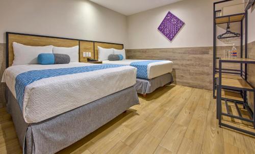 ein Hotelzimmer mit zwei Betten und einem Tisch in der Unterkunft Continental Mexicano in Mexiko-Stadt