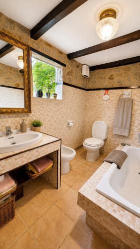 a bathroom with a tub and a toilet and a sink at La casita "A de Naval" in Pontevedra