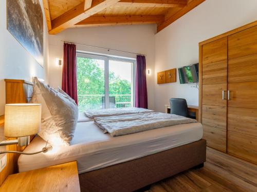 a bedroom with a large bed and a window at Adlerblick in Werfenweng