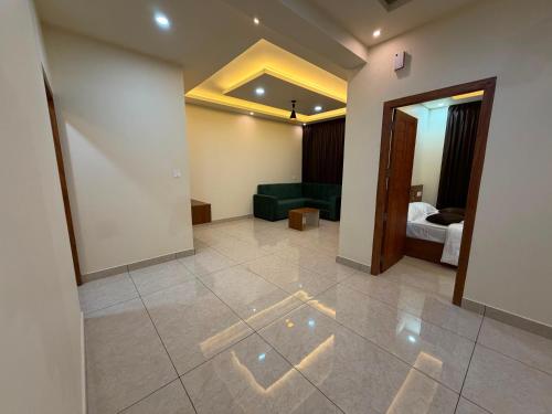 a living room with a green couch and a bedroom at Hide Away in Padinjarathara