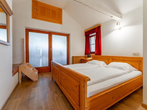 a bedroom with a wooden bed and a window at Zederhaus in Mariapfarr