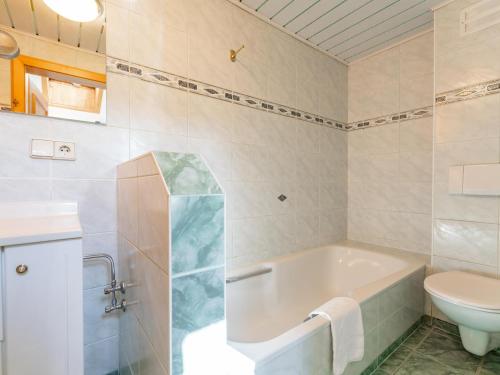 a bathroom with a tub and a toilet at Zederhaus in Mariapfarr