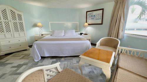 ein Schlafzimmer mit einem großen weißen Bett und einem Tisch in der Unterkunft Hotel Acapulco Malibu in Acapulco