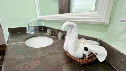 Ein Schwan sitzt auf einem Waschbecken im Badezimmer. in der Unterkunft Hotel Acapulco Malibu in Acapulco