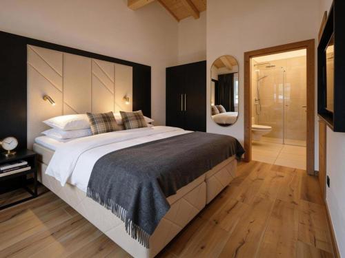 a bedroom with a large bed and a bathroom at Grebenzen 66 in Sankt Lambrecht