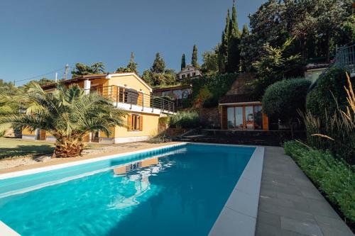 a swimming pool in front of a house at Piran Panorama Pool Villa in Piran