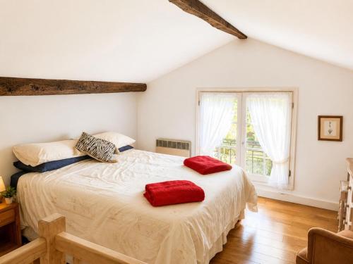 a bedroom with a bed with two red pillows on it at Petit Vingne in Édon