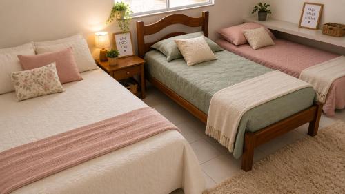 a bedroom with two beds with pink and green sheets at Pousadinha Mel -DORMITÓRIOS in Salvador