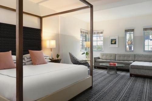 a hotel room with a bed and a couch at Kimpton Surfcomber Hotel by IHG in Miami Beach