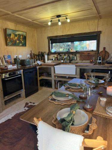 a kitchen with a wooden table with a counter top at Rangitoto Retreat Raglan in Te Akau