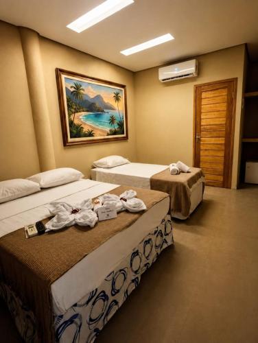 a hotel room with two beds with towels on them at Pousada Numei de Jeri in Jericoacoara