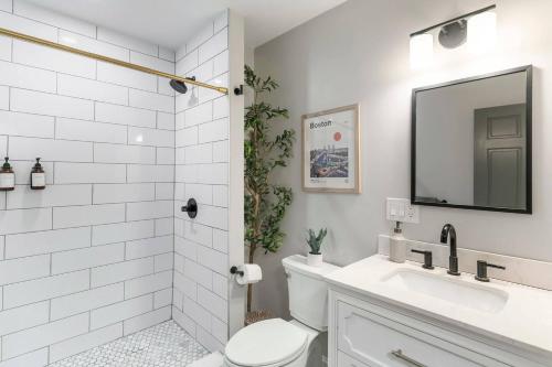 a white bathroom with a toilet and a sink at Sky Deck | Downtown in Boston