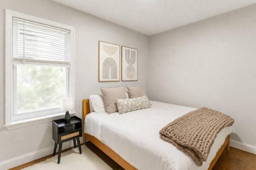 a white bedroom with a bed and a window at Sky Deck | Downtown in Boston