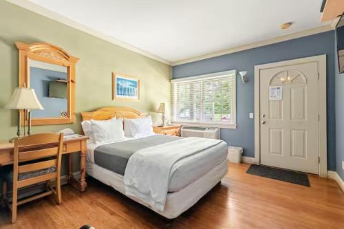 a bedroom with a large bed and a desk and a door at Southampton Long Island Hotel in Southampton