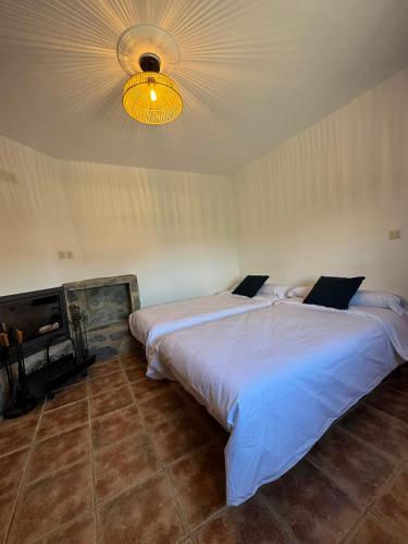 two beds in a bedroom with a light on the ceiling at AT El Cordel in Nogales