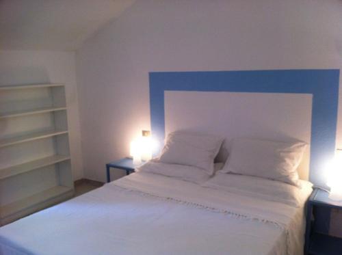 ヴィッラシミーウスにあるSul Mare Sardegna Villa Acteaのベッドルーム(白い大型ベッド、ランプ2つ付)
