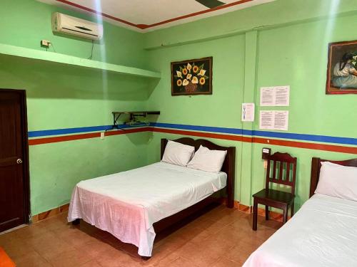 a room with two beds and a chair in it at HotelMariaAngela in Dzuiché