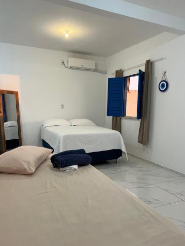 a room with two beds and a flat screen tv at Apartamento da Kenia in Canoa Quebrada