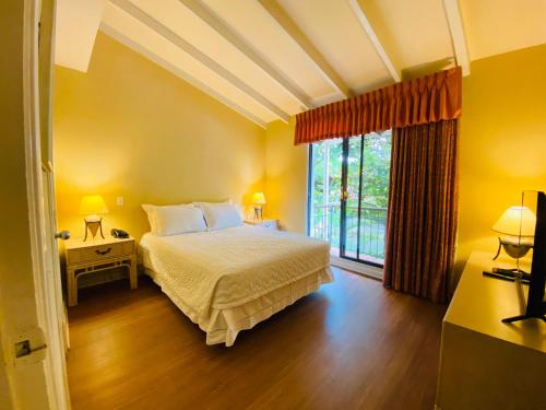 a bedroom with a bed and a large window at Aparthotel La Quinta in Santa Cruz de la Sierra