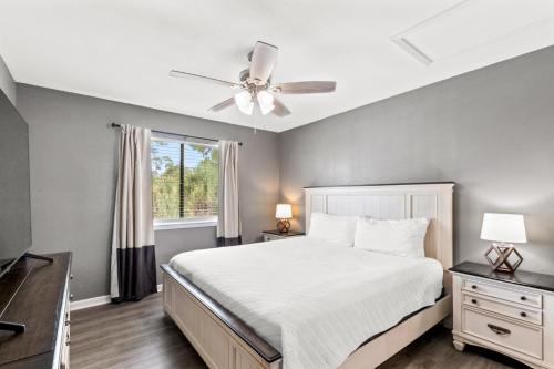 a bedroom with a bed and a ceiling fan at Wolf Bay Villas in Orange Beach