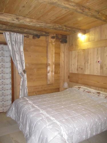 a bedroom with a bed in a wooden cabin at Appartamento Le Jardin CIR VDA Aymavilles 0009 in Aymavilles