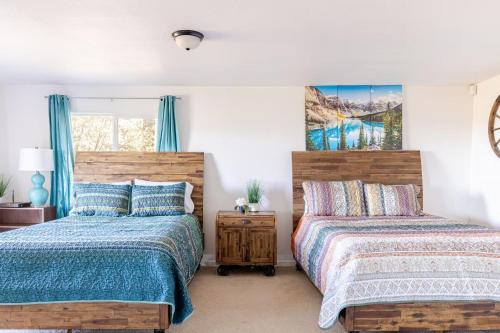 two beds in a bedroom with blue curtains at Riverfalls Retreat in Oakhurst