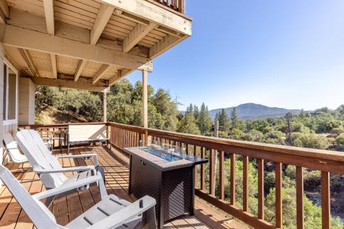a porch with white chairs and a table on it at Riverfalls Retreat in Oakhurst