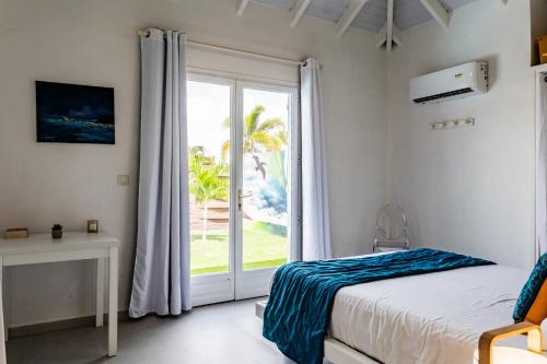 a bedroom with a bed and a sliding glass door at Villa Madame in Saint Martin