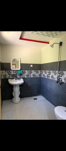 a bathroom with a sink and a tv on the wall at Stone Leaf Retreat - Skardu in Skardu
