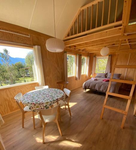 a bedroom with a table and a bed and a ladder at Cabaña Raymapu in Puelo