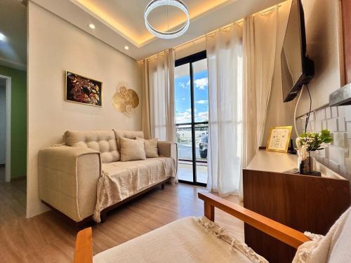 a living room with a couch and a window at Lunar Lua Nova 06 in Aracaju
