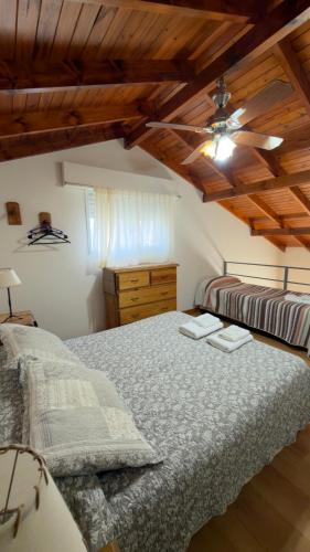 a bedroom with two beds and a ceiling fan at Cabañas Hueney Ruca in Sierra de la Ventana