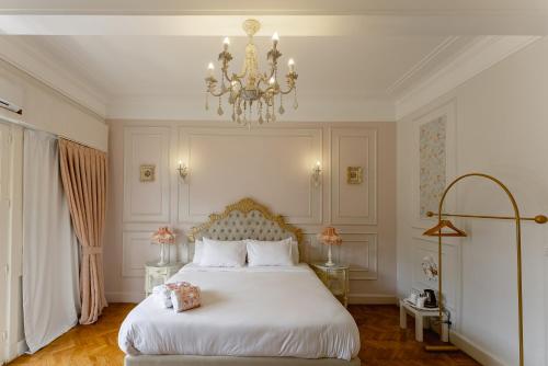 a bedroom with a white bed and a chandelier at El Otel Hotel in Cairo