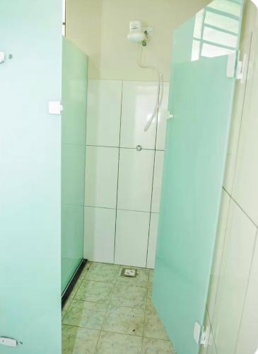 a bathroom with a shower with a glass door at Casa de campo - chácara Guinato in Socorro