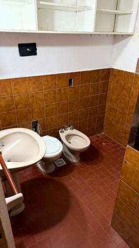 a bathroom with a toilet and a sink at Casa Thompson in Paraná