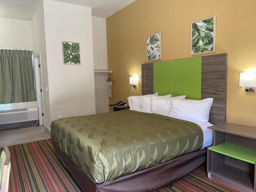 a hotel room with a bed with a green headboard at Quality Inn in Elgin