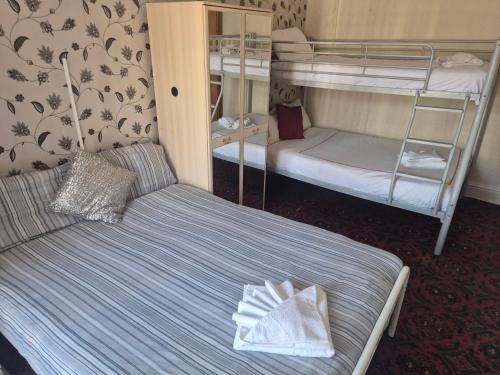 a room with two bunk beds and a bed with towels at White Moon Hotel in Blackpool