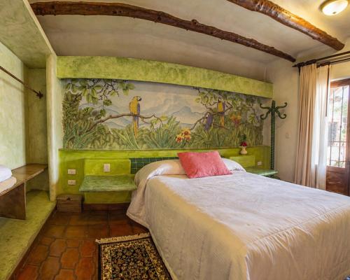a bedroom with a bed with a painting on the wall at Hotel Quinta Bella in Tula de Allende