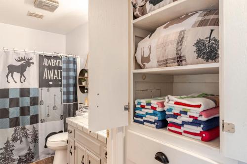 a bathroom with a shelf with folded towels at Peaceful Chalet in Oakhurst