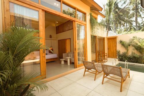 a house with a pool and two chairs on a patio at enn Collection in Kuta Lombok