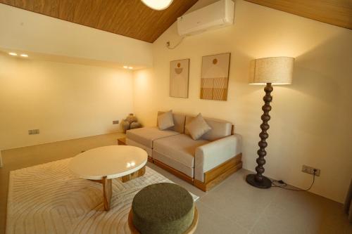 a living room with a couch and a table at enn Collection in Kuta Lombok