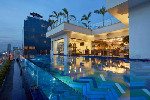 a building with a swimming pool at night at Mandarina Colombo in Colombo